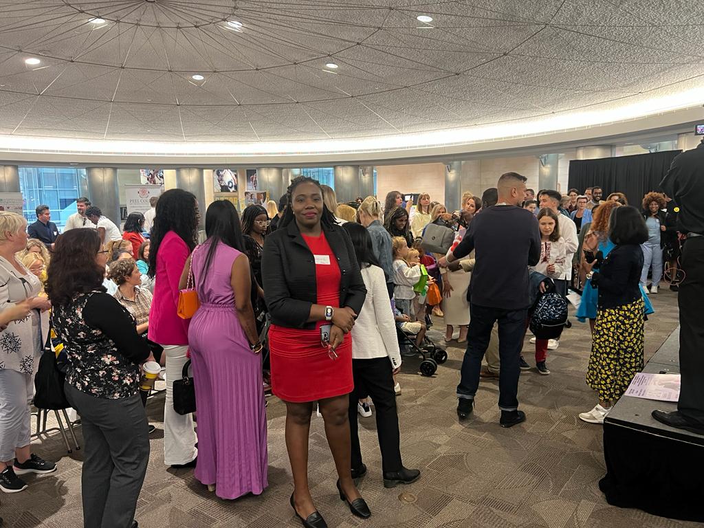 Women standing together at a busy indoor community gathering