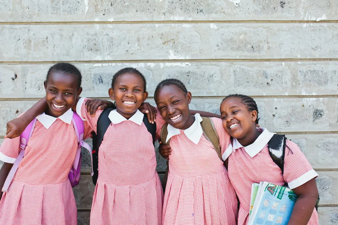 Girls standing together with books and backpacks